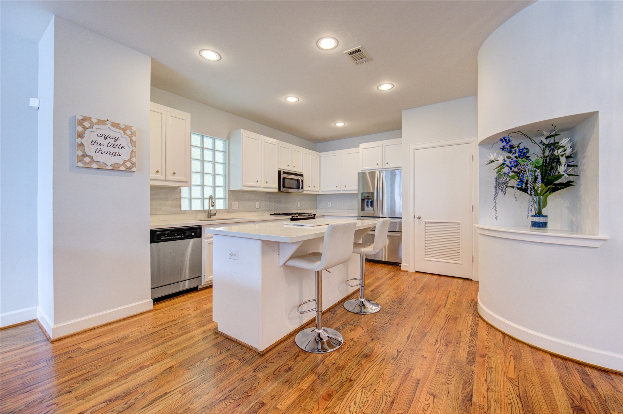 a kitchen with white cabinets and stainless steel appliances