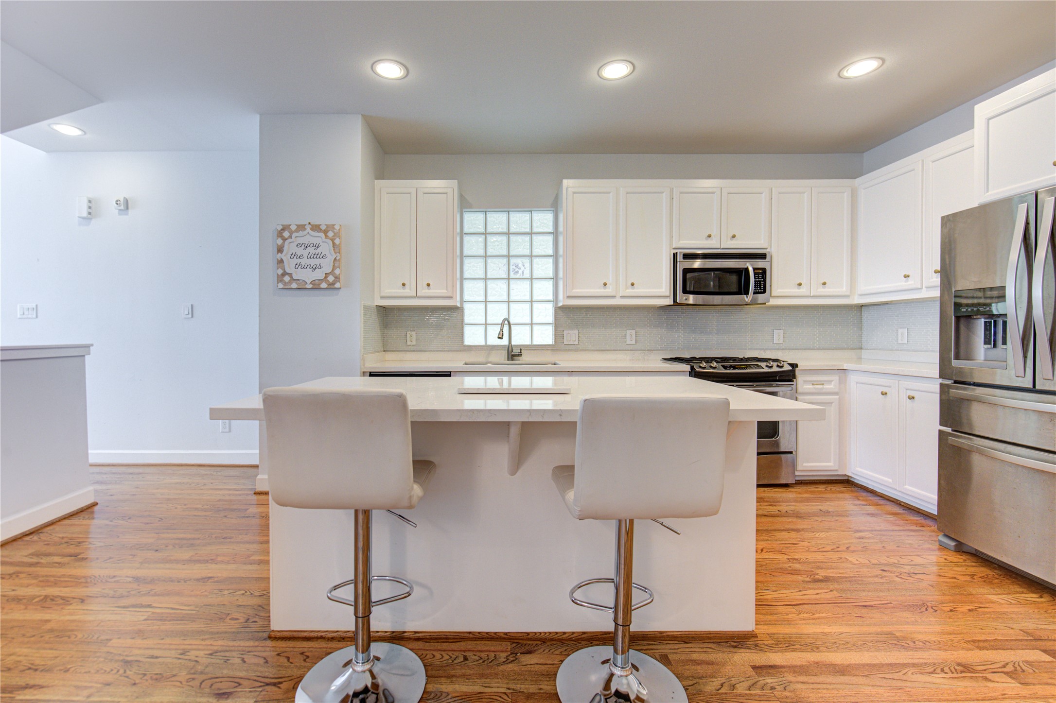 650 Westcross Street, Unit 83 Houston, TX 77018 - Photo 21 of 48 a kitchen with kitchen island white cabinets and stainless steel appliances