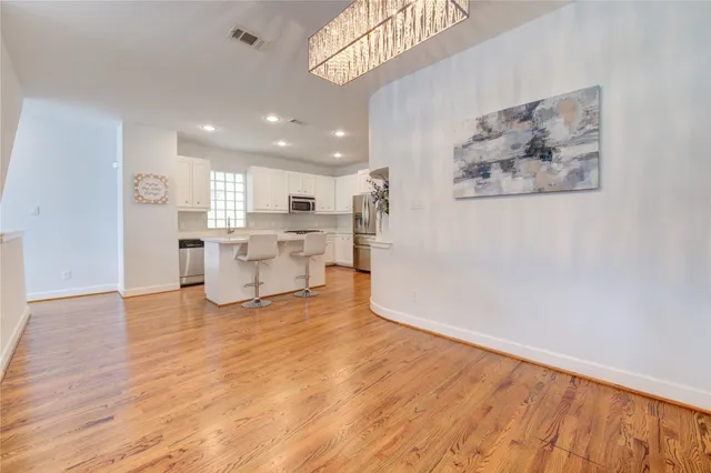 a view of empty room with wooden floor and window
