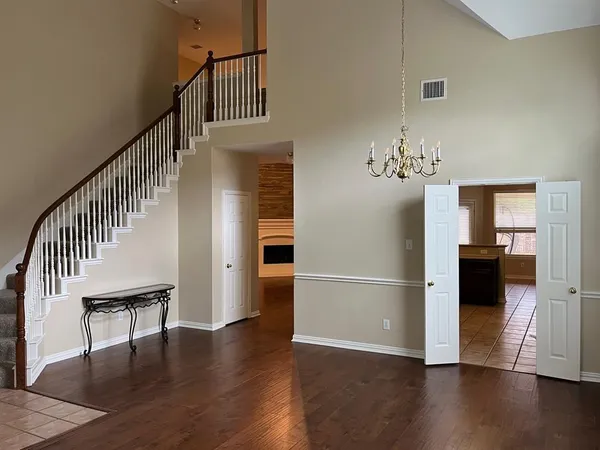 a view of a hallway with wooden floor and staircase