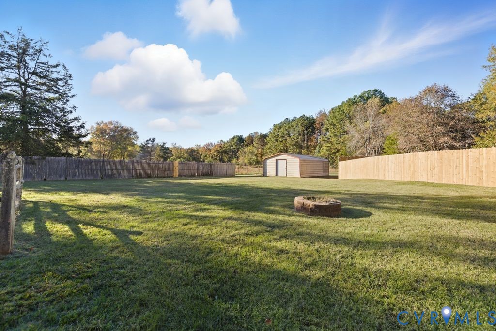 1601 Holly Hills Road Powhatan, VA 23139 - Photo 24 of 32 Fenced backyard with an outdoor fire pit and a sto