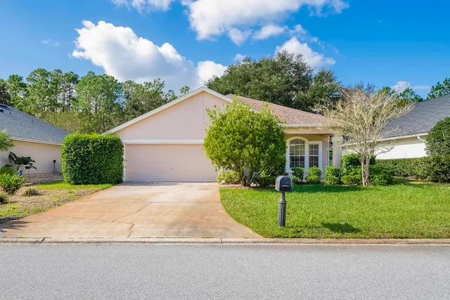 a view of a white house with a yard and plants
