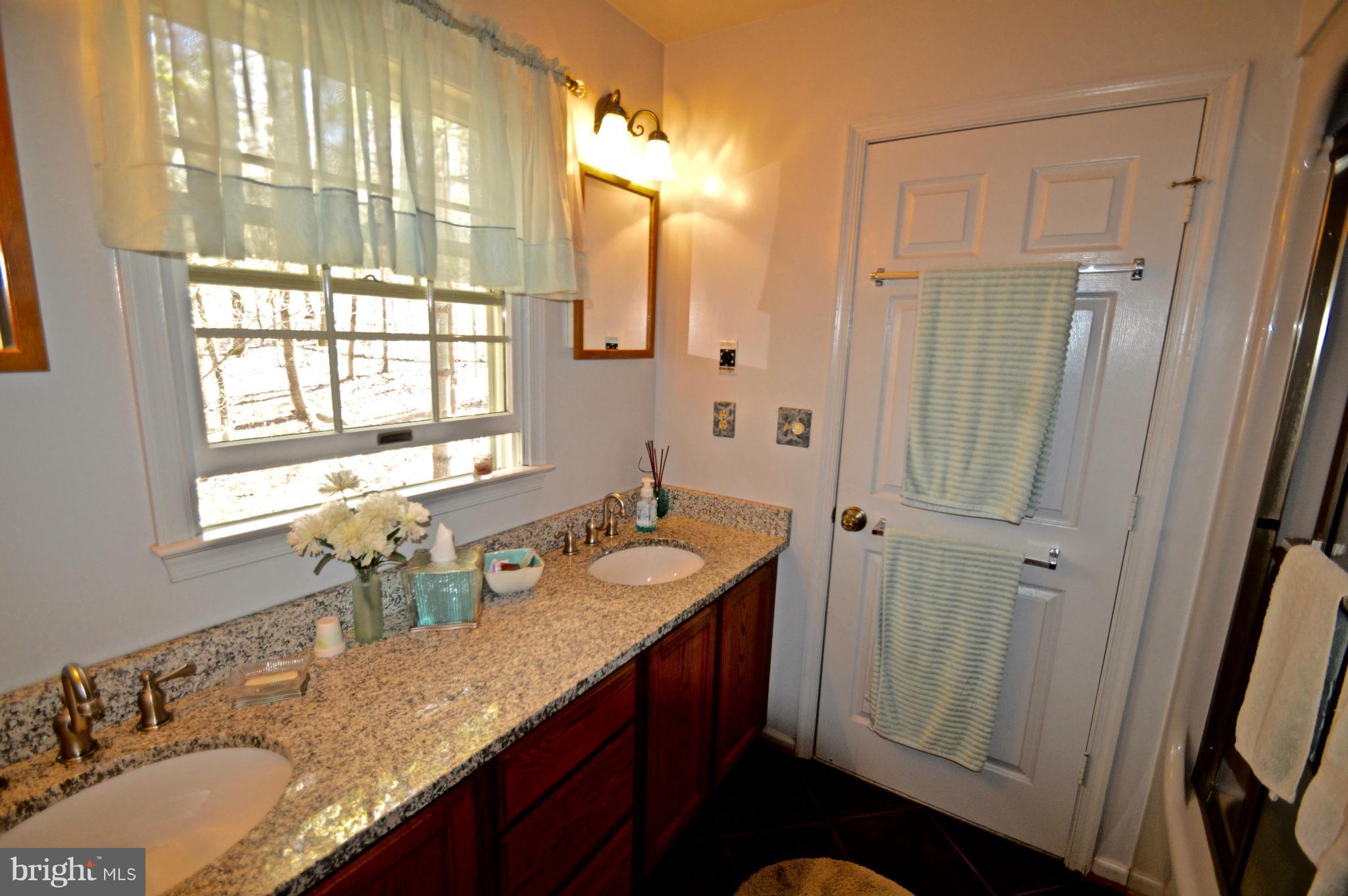 3800 Roop Road New Windsor, MD 21776 - Photo 24 of 29 a bathroom with a granite countertop sink a mirror a vanity and a shower