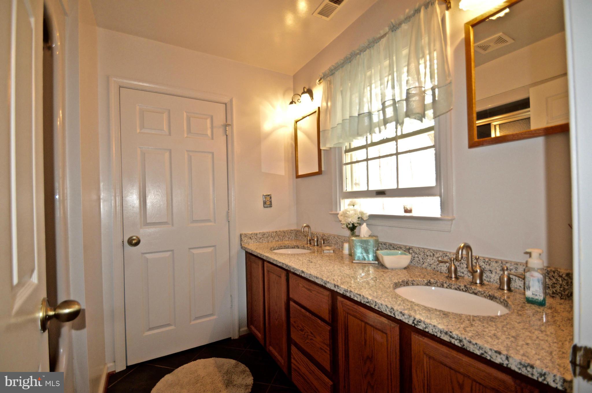 3800 Roop Road New Windsor, MD 21776 - Photo 25 of 29 a bathroom with a granite countertop sink a mirror and a shower