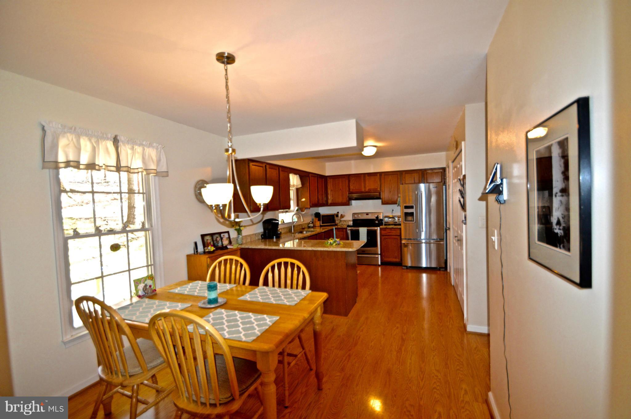 3800 Roop Road New Windsor, MD 21776 - Photo 7 of 29 a view of a dining room and livingroom with furniture wooden floor a chandelier