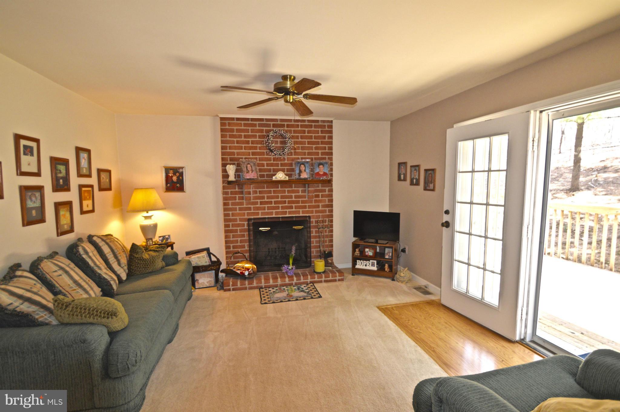 3800 Roop Road New Windsor, MD 21776 - Photo 10 of 29 a living room with furniture a fireplace and a large window