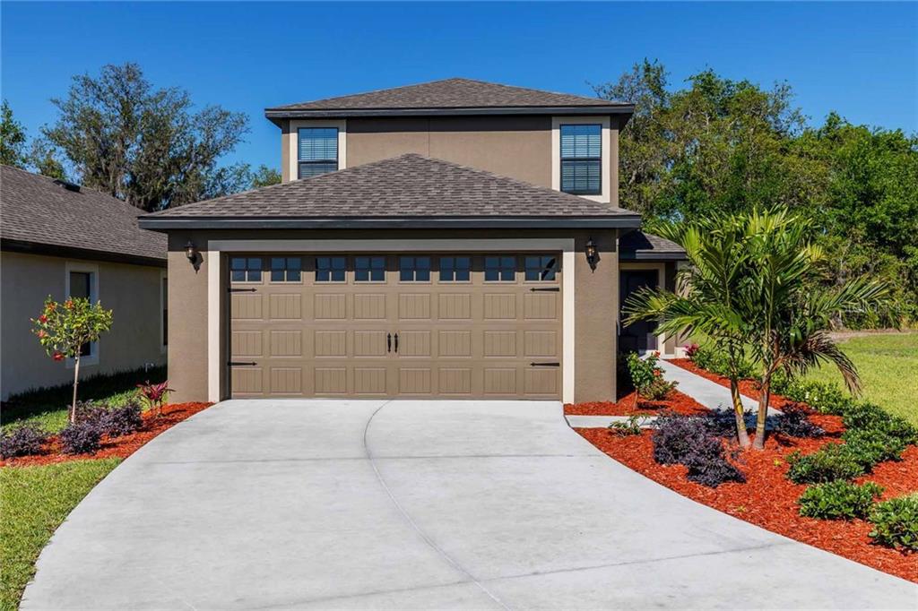 8331 Silverbell Loop Brooksville, FL 34613 - Photo 1 of 1 a front view of a house with a garden