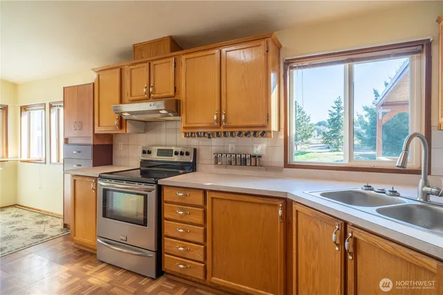 a kitchen with stainless steel appliances a stove sink and cabinets