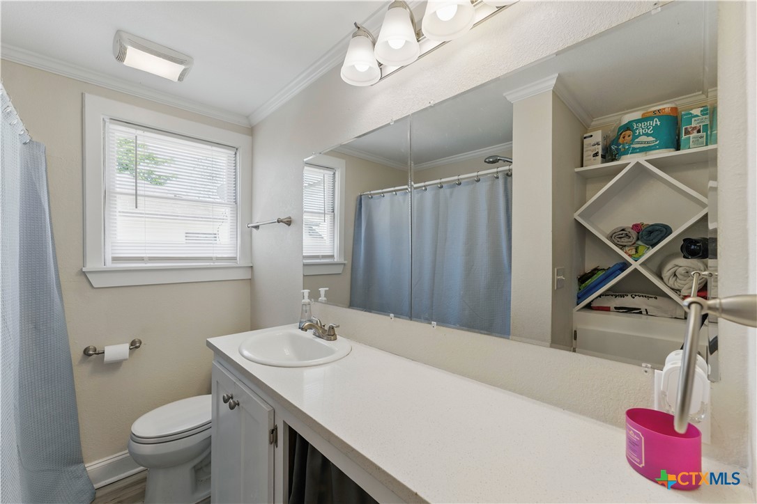 411 Ellis Street Seguin, TX 78155 - Photo 15 of 28 a bathroom with a sink a toilet and a mirror