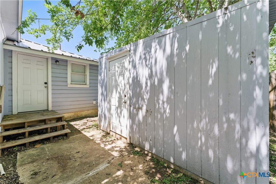411 Ellis Street Seguin, TX 78155 - Photo 20 of 28 a backyard of a house with a large tree and wooden fence