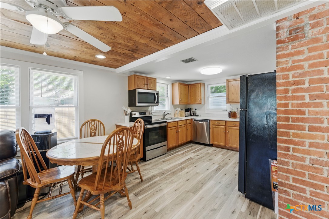 411 Ellis Street Seguin, TX 78155 - Photo 7 of 28 a kitchen with a dining table chairs and refrigerator