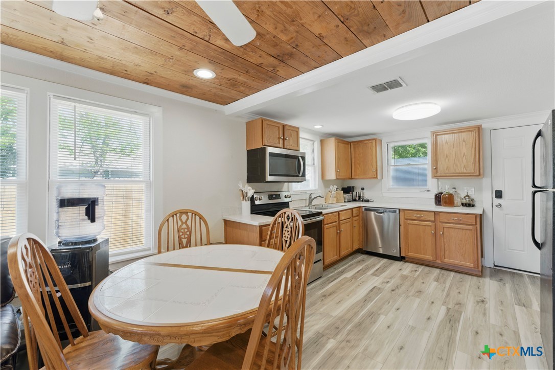 411 Ellis Street Seguin, TX 78155 - Photo 8 of 28 a large kitchen with a table chairs wooden cabinets and stainless steel appliances