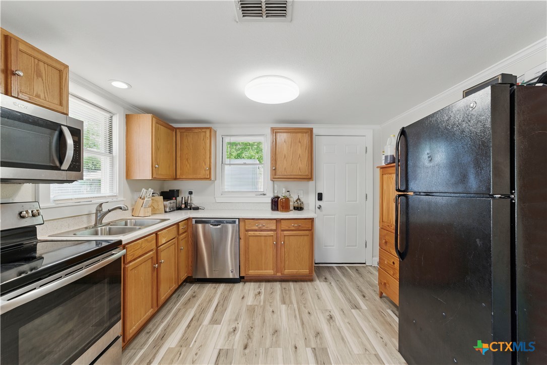 411 Ellis Street Seguin, TX 78155 - Photo 10 of 28 a kitchen with a refrigerator stove and sink