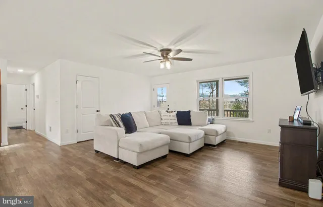 a living room with furniture flat screen tv and window