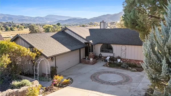 an aerial view of a house with a yard and large trees