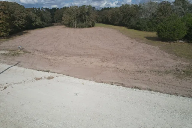 a view of a dry yard with green space