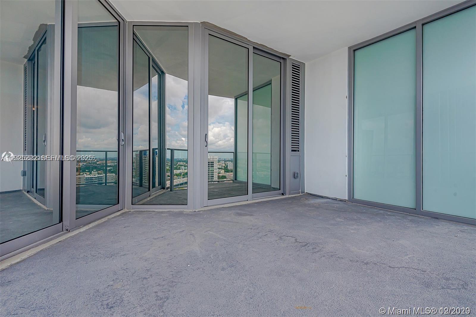 851 Northeast 1st Avenue, Unit 1608 Miami, FL 33132 - Photo 11 of 34 an empty room with floor to ceiling windows
