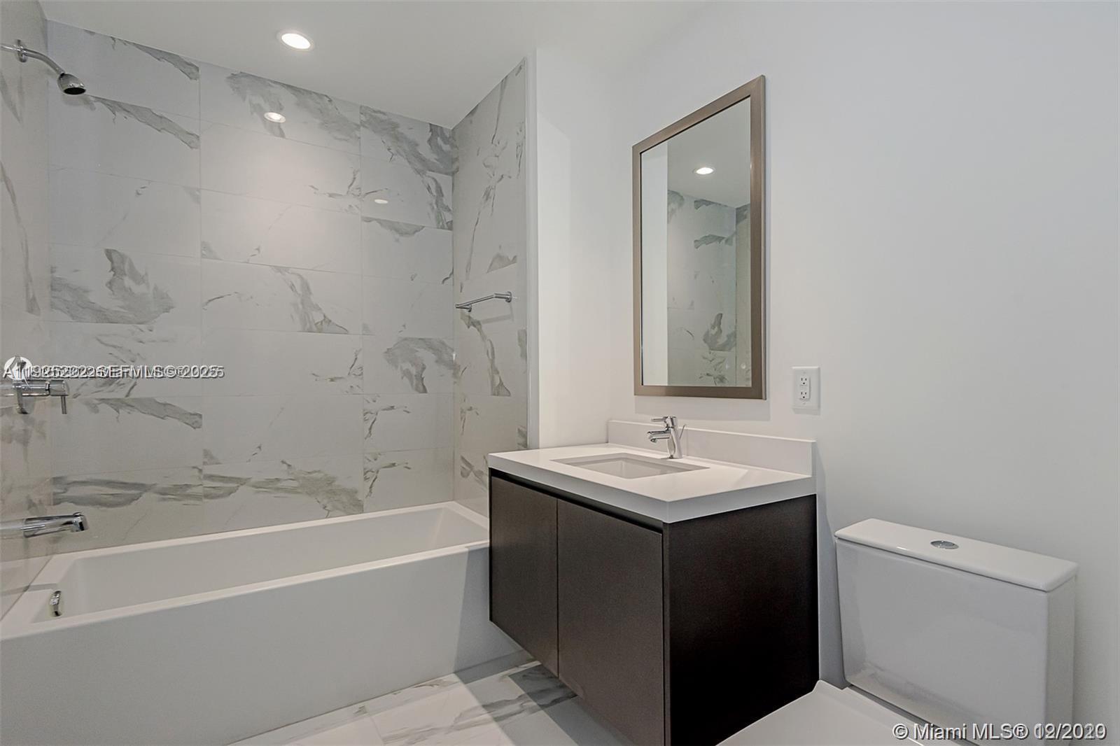 851 Northeast 1st Avenue, Unit 1608 Miami, FL 33132 - Photo 17 of 34 a bathroom with a sink toilet vanity and shower