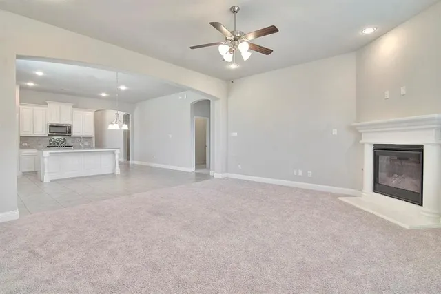 a view of an empty room and kitchen view