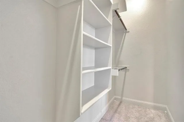 a large white kitchen with kitchen island a sink stainless steel appliances and cabinets