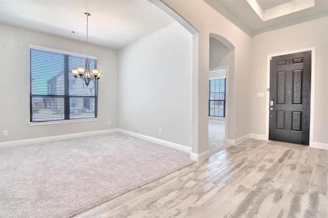 a view of an empty room with window and cabinet