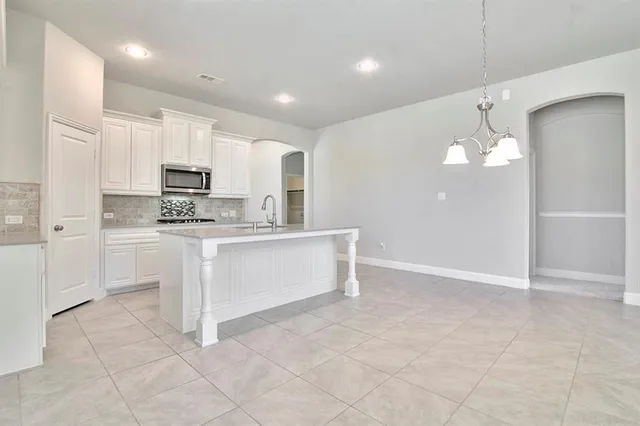 a large white kitchen with cabinets