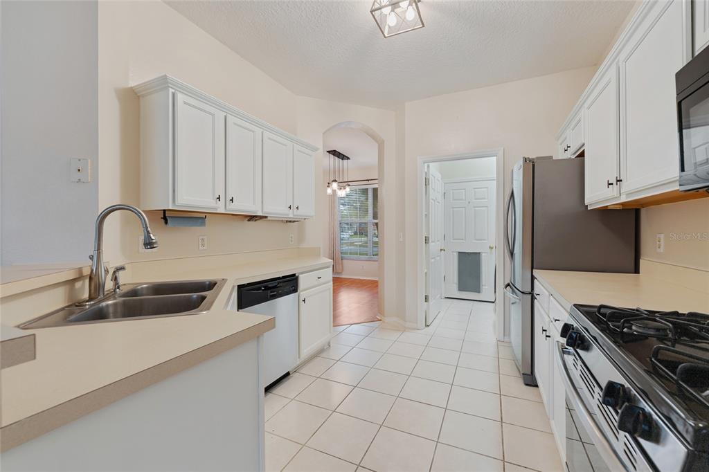 1073 Turtle Lake Court Ocoee, FL 34761 - Photo 24 of 46 a kitchen with granite countertop a sink stove and refrigerator