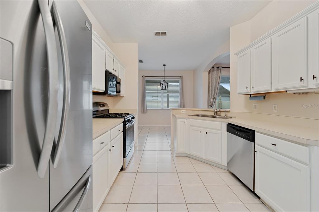 1073 Turtle Lake Court Ocoee, FL 34761 - Photo 25 of 46 a kitchen with white cabinets and white appliances