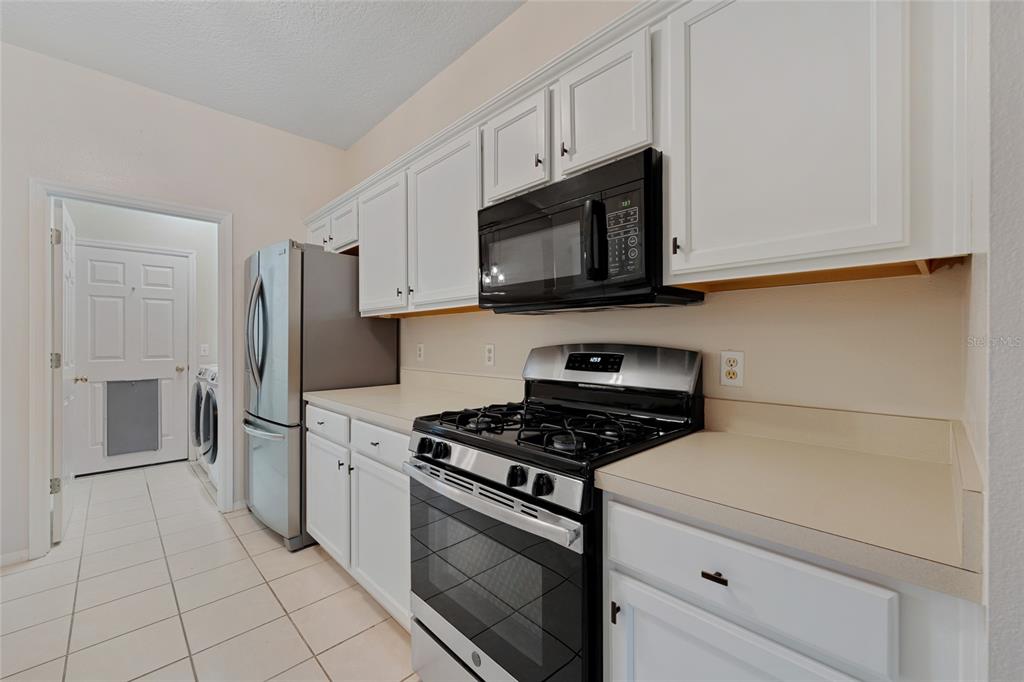 1073 Turtle Lake Court Ocoee, FL 34761 - Photo 26 of 46 a kitchen with granite countertop white cabinets and stainless steel appliances
