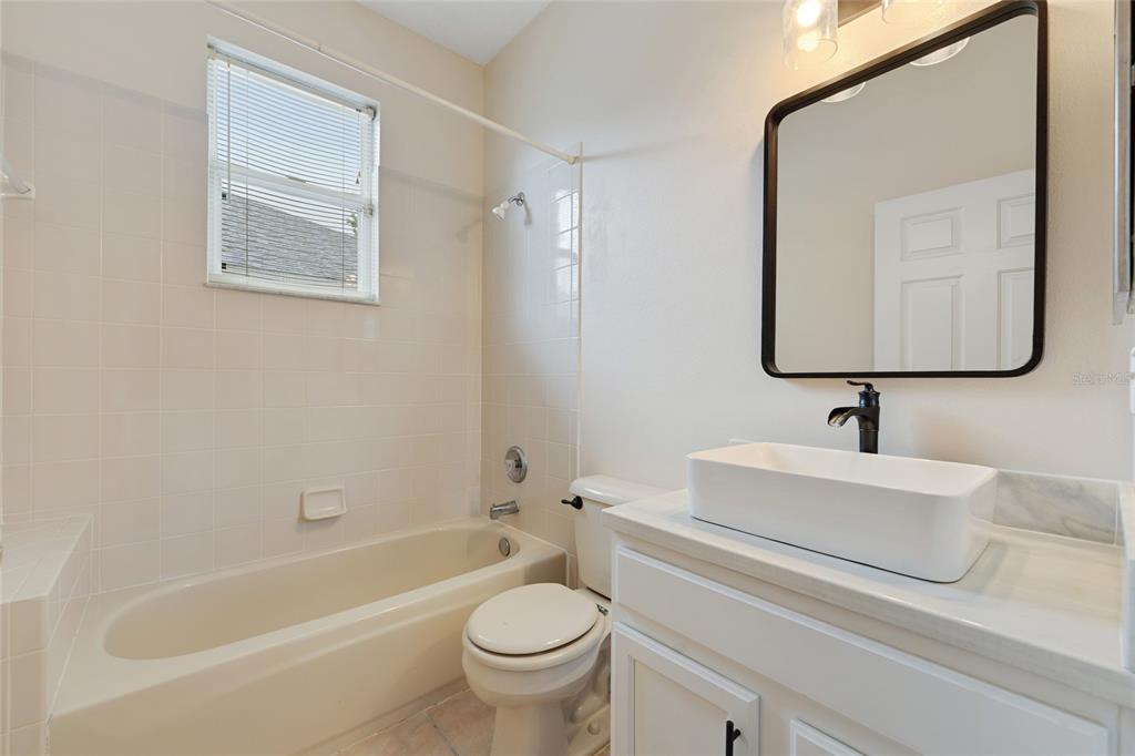 1073 Turtle Lake Court Ocoee, FL 34761 - Photo 38 of 46 a bathroom with a toilet a sink a mirror and bathtub