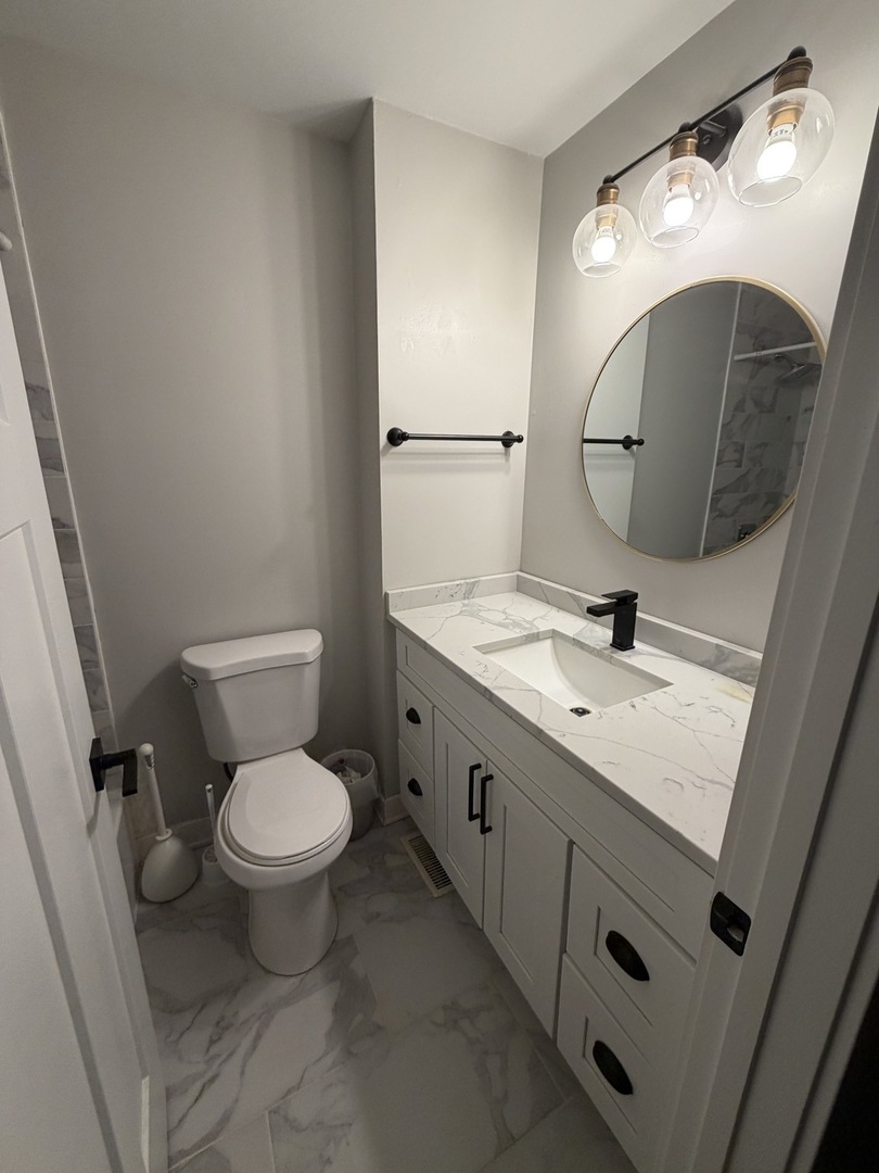 335 David Court, Unit B Bartlett, IL 60103 - Photo 11 of 16 a bathroom with a toilet sink and mirror