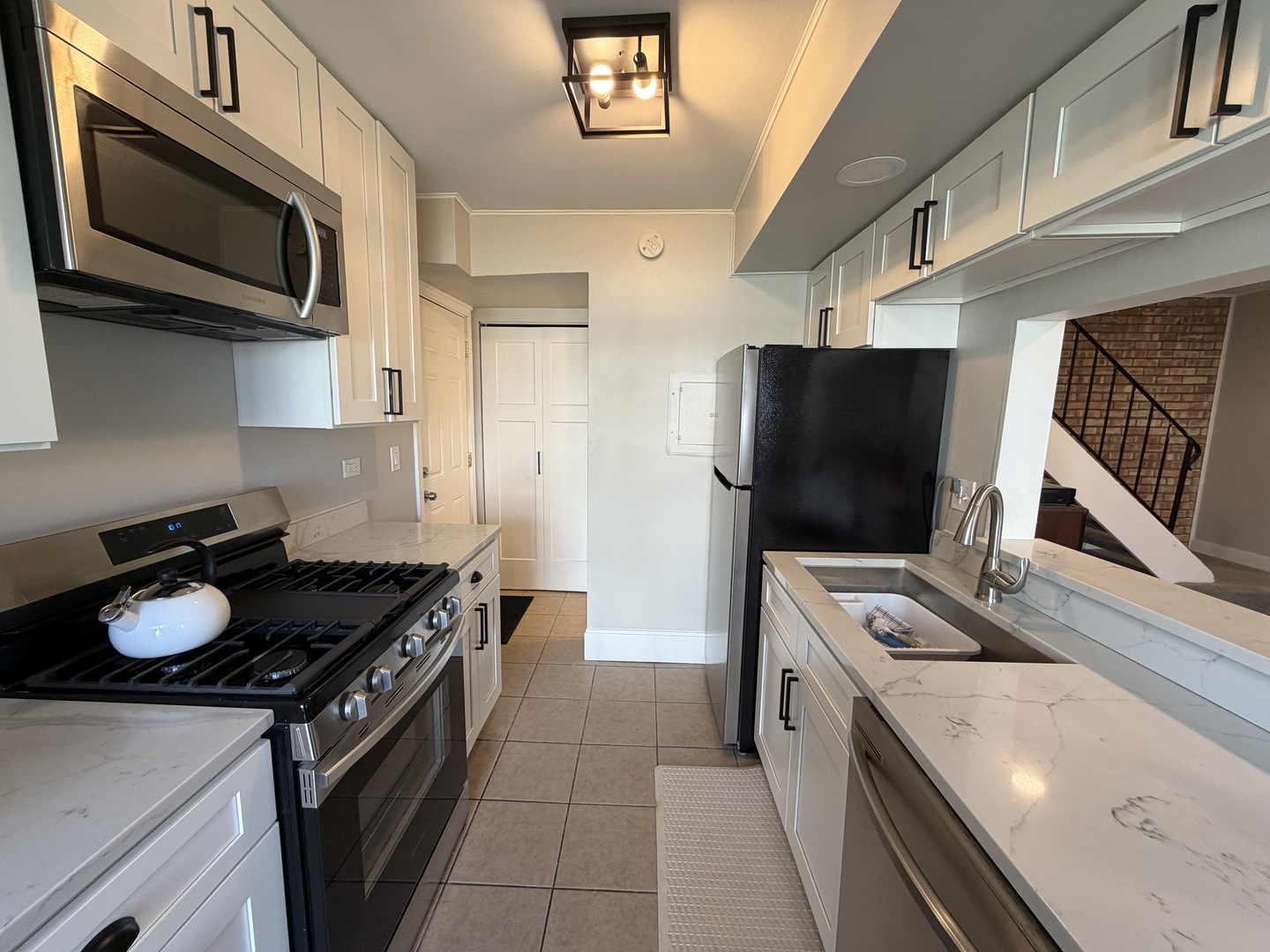 335 David Court, Unit B Bartlett, IL 60103 - Photo 5 of 16 a kitchen with stainless steel appliances a stove a microwave and a sink