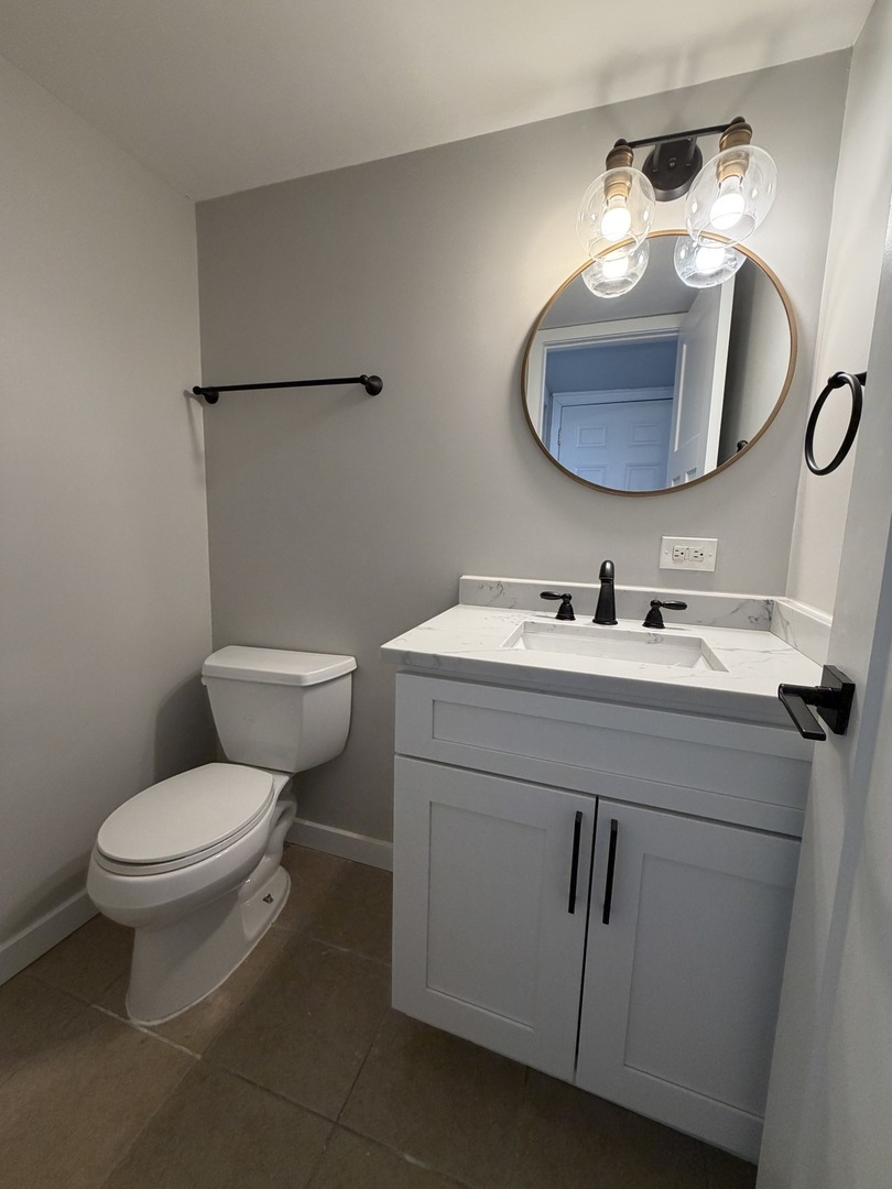 335 David Court, Unit B Bartlett, IL 60103 - Photo 6 of 16 a bathroom with a toilet sink and mirror