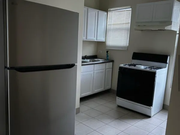 a kitchen with a stove top oven and cabinets