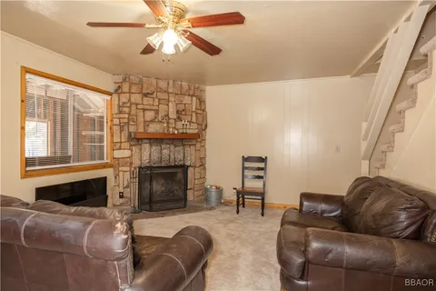 a living room with furniture a fireplace and a chandelier