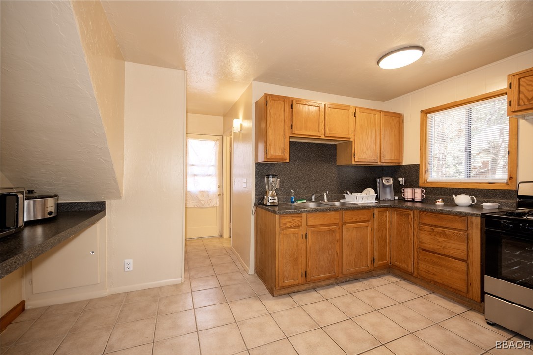 809 San Bernardino Avenue Sugarloaf, CA 92386 - Photo 6 of 23 a kitchen with stainless steel appliances granite countertop a sink and cabinets