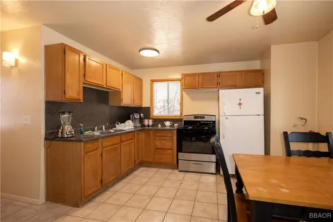 a kitchen with granite countertop a refrigerator stove top oven and sink