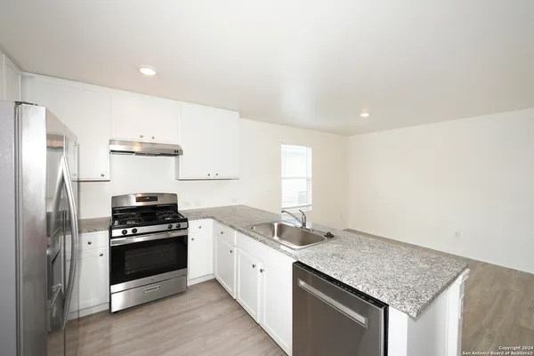 a kitchen with granite countertop stainless steel appliances and sink