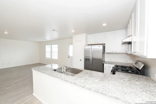 a kitchen with stainless steel appliances granite countertop a sink refrigerator and stove