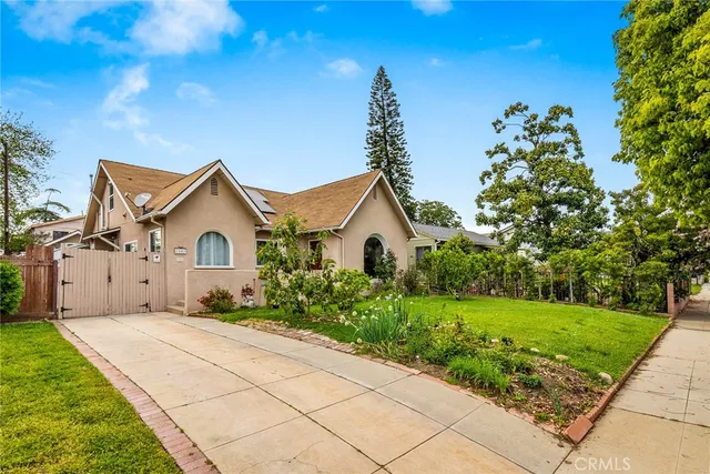 a view of a house with a yard and potted plants
