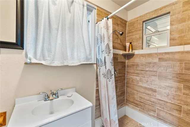 a bathroom with a sink a mirror and shower