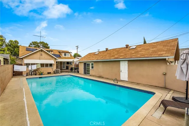 a view of a house with pool and yard