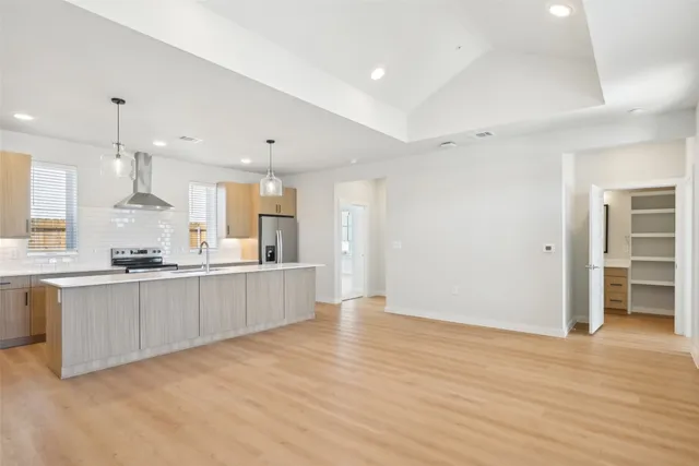 a large kitchen with kitchen island a sink stainless steel appliances and cabinets