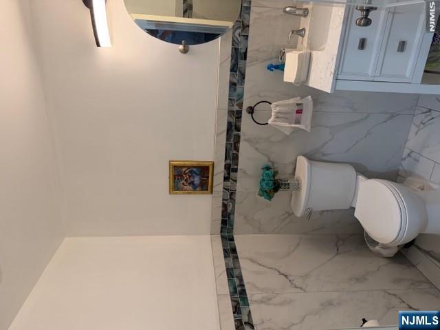 177 Maple Street Fairview, NJ 07022 - Photo 5 of 24 a white toilet sitting next to a bathroom sink
