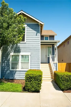 a front view of a house with a yard and potted plants