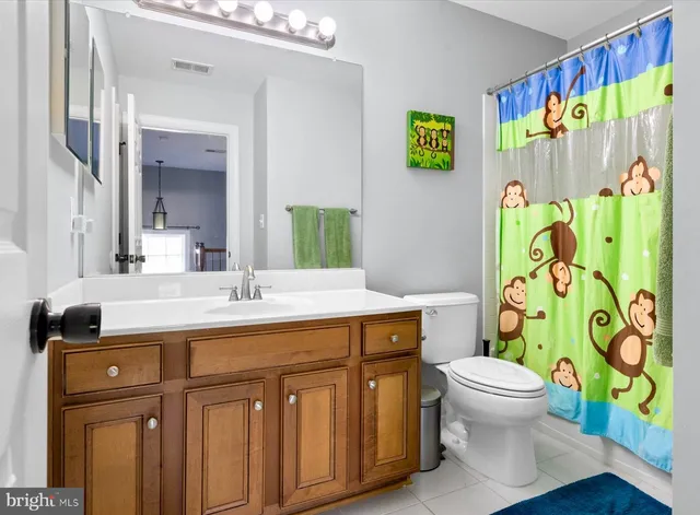 a bathroom with a granite countertop sink and a toilet