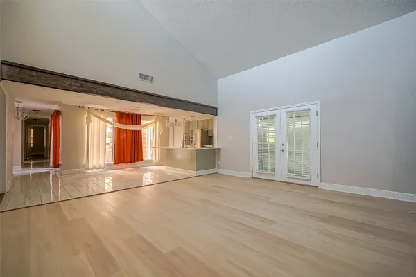 an empty room with wooden floor and windows