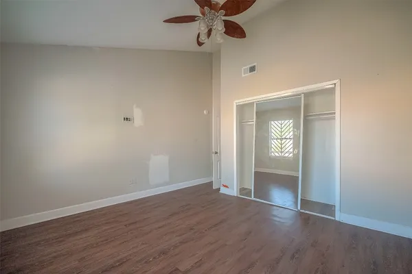 a view of an empty room with window and wooden floor