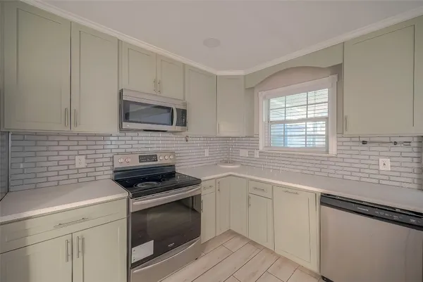 a kitchen with white cabinets appliances and a sink
