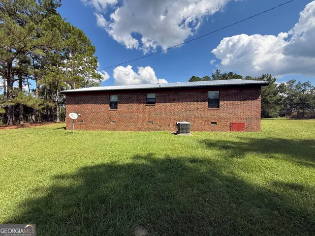 a front view of house with garden and trees